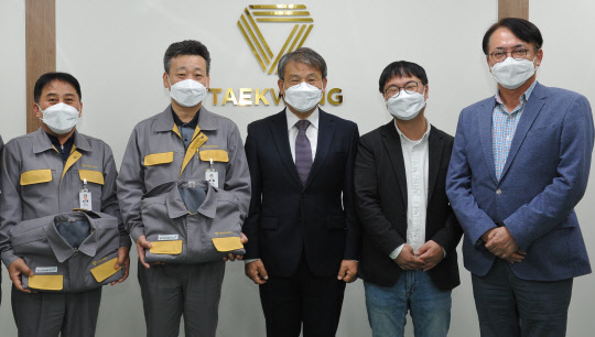 지난달 29일 태광산업 울산공장 대회의실에서 진행된 임직원 대상 친환경 작업복 지급행사에서 박재용(오른쪽) 태광산업 섬유사업본부 대표이사를 비롯한 참석자들이 기념촬영하고 있다. <태광산업 제공>